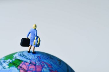 miniature traveler woman on the globe clipart