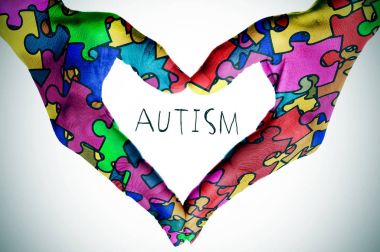 puzzle parçaları metin otizm ve eller bir kalp ile şekillendirme