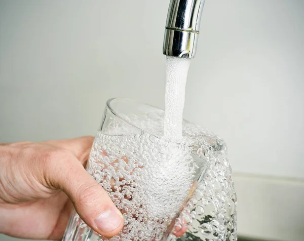 Homme remplissant un verre d'eau du robinet — Photo