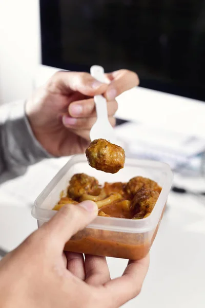 Junger Mann isst im Büro — Stockfoto