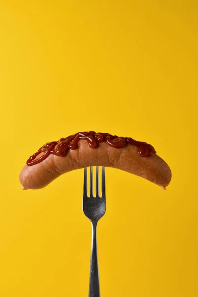 Hotdog met ketchup in een vork — Stockfoto