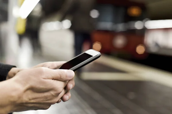 Mann benutzt Smartphone in U-Bahn-Station — Stockfoto