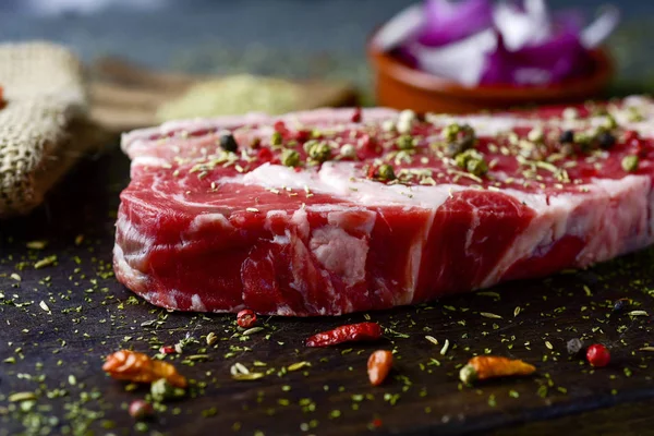 Filete de tira cruda sazonado con diferentes especias — Foto de Stock