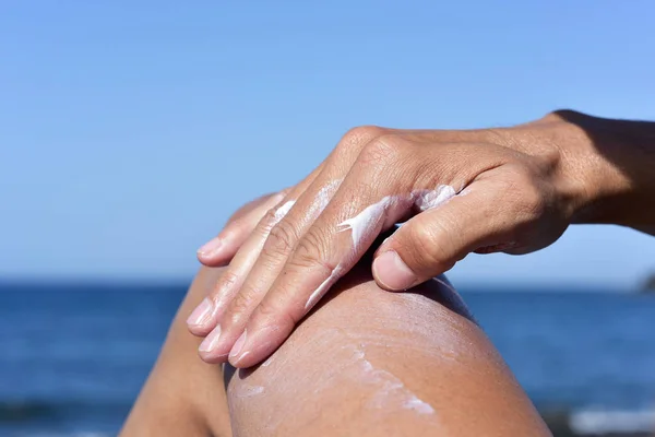 Man applying sunscreen to his thigh — Stock Photo, Image