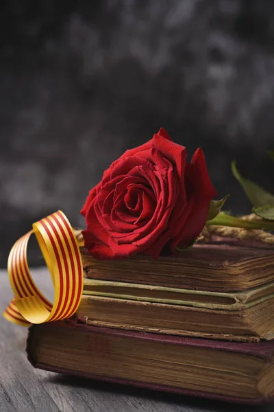 Rose rouge, drapeau catalan et vieux livres — Photo