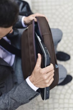 bir dizüstü bilgisayar bir evrak çantası'dışına alarak iş adamı