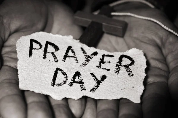 Man with crucifix and text prayer day — Stock Photo, Image