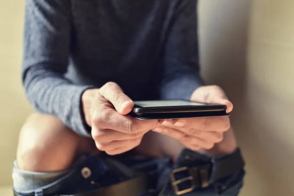 Young man reading in the toilet — Stock Photo, Image