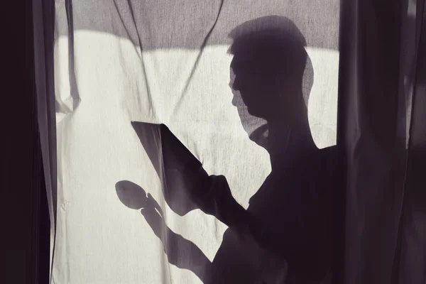 Silhouette dell'uomo con caup e tablet — Foto Stock