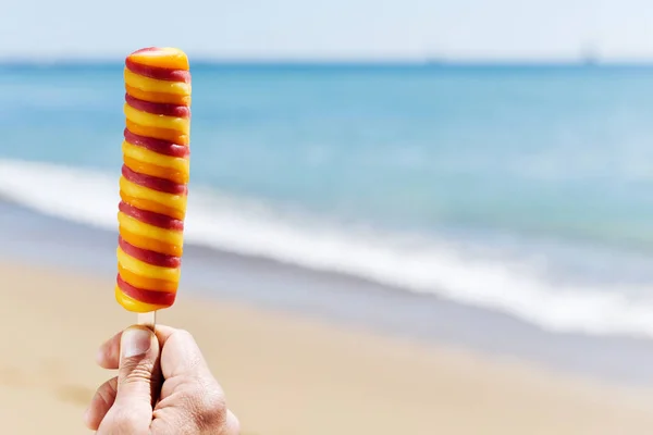 Člověk jíst zmrzlinu na pláži — Stock fotografie