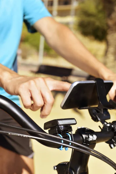 Νεαρός άνδρας χρησιμοποιώντας ένα smartphone, κάνετε ποδήλατο — Φωτογραφία Αρχείου