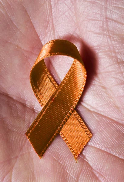 Orange ribbon on the palm — Stock Photo, Image