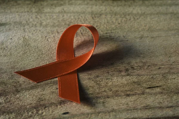 Orange ribbon on a wooden surface — Stock Photo, Image