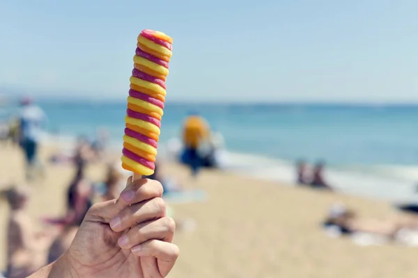 ビーチでアイス キャンデーを食べる男 — ストック写真