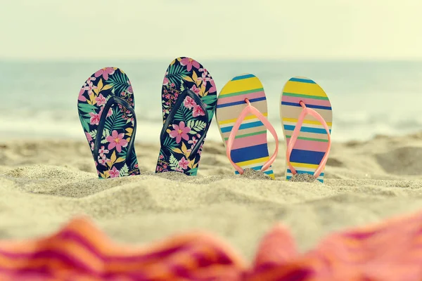 Twee paar slippers op het strand — Stockfoto