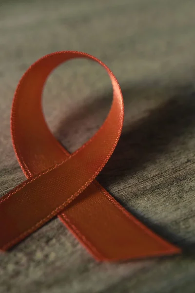 Orange ribbon on a wooden surface — Stock Photo, Image