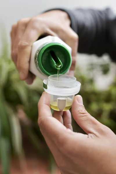 Man measuring a dose of liquid fertilizer — Stock Photo, Image