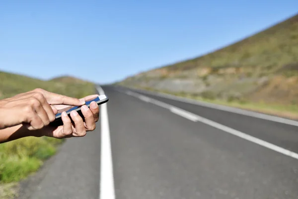 Homme utilisant un smartphone à côté de la route — Photo