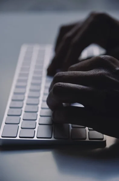 Jeune homme tapant dans un clavier d'ordinateur — Photo