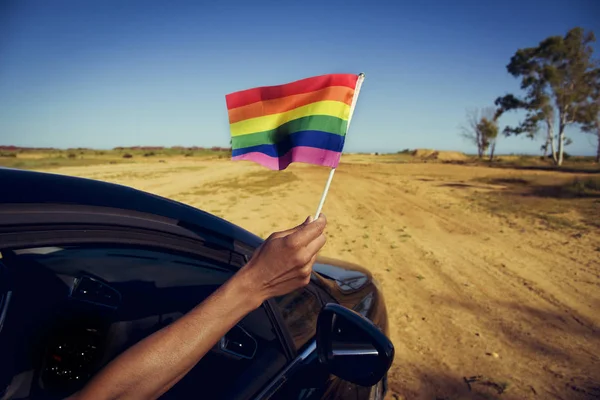 Hombre ondeando una pequeña bandera de arco iris —  Fotos de Stock