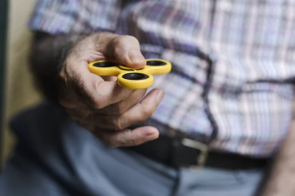Viejo hombre jugando con un fidget spinner —  Fotos de Stock