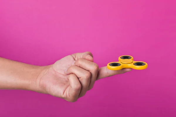 Young man playing with a fidget spinner — Stock Photo, Image