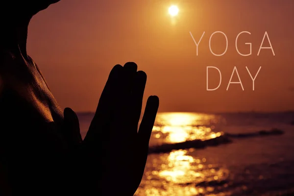 Man met zijn handen samen te stellen en de tekst yoga dag — Stockfoto