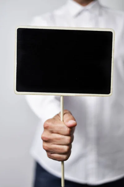 Jeune homme avec un panneau noir vierge — Photo