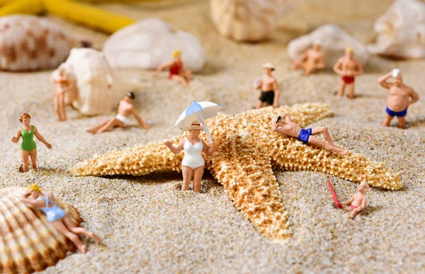 Miniaturmenschen im Badeanzug am Strand — Stockfoto