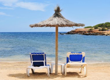 umbrella and sunloungers in Ibiza, Spain clipart