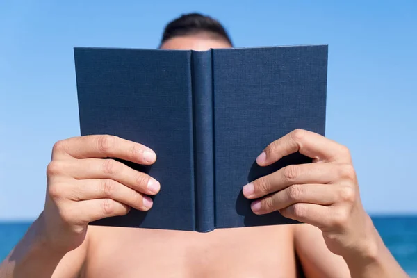 Mann liest ein Buch am Strand — Stockfoto