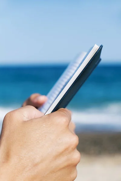 Mann liest ein Buch am Strand — Stockfoto