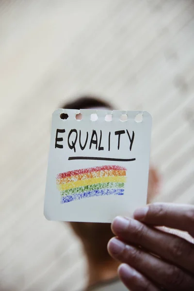 Bandeira do arco-íris e igualdade de palavras em uma nota — Fotografia de Stock