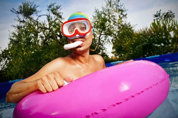 Uomo che nuota in una piscina portatile — Foto Stock