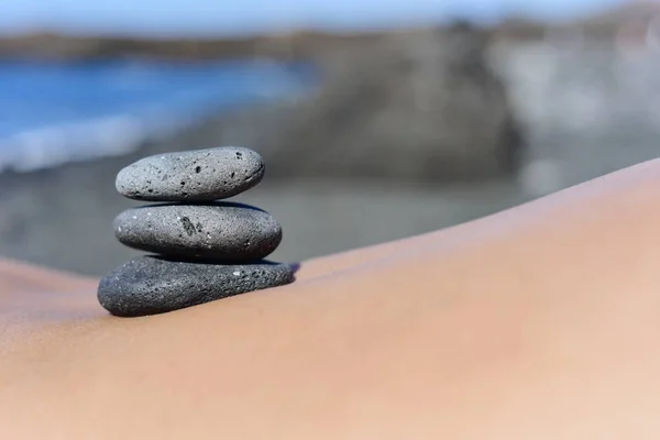 Pedras na parte de trás de um homem na praia — Fotografia de Stock