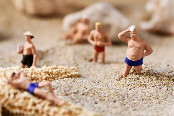 Miniature men in swimsuit on the beach — Stock Photo, Image