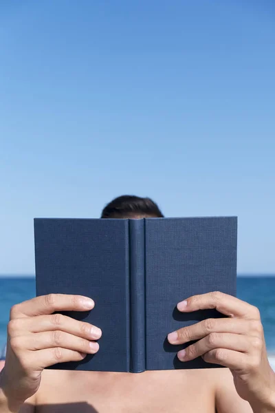 Mann liest ein Buch am Strand — Stockfoto