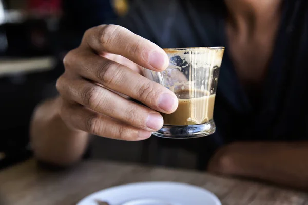 Mladý muž s macchiato v kavárně — Stock fotografie