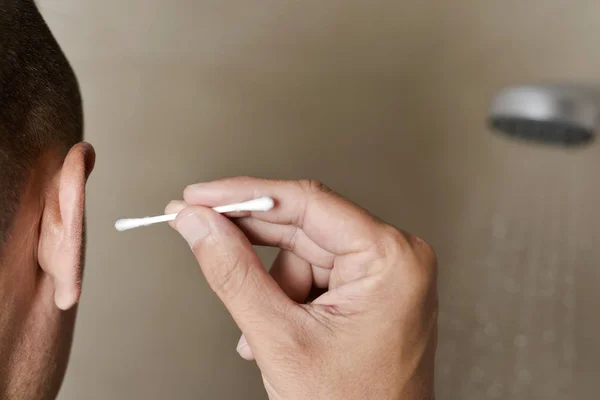 Young man about to use a cotton swab — Stock Photo, Image