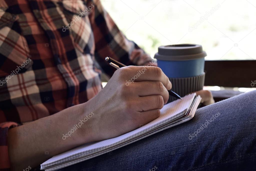 young man writing in a notebook