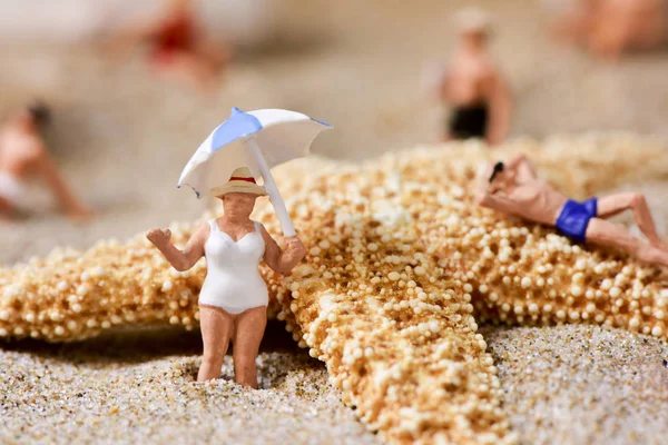 Pessoas em miniatura em maiô na praia — Fotografia de Stock