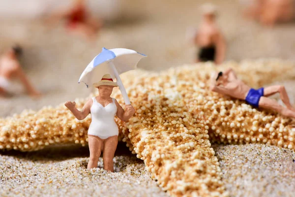 Miniature people in swimsuit on the beach — Stock Photo, Image