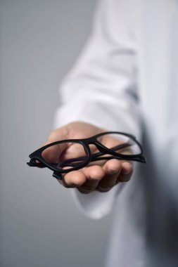 optician man bringing a pair of eyeglasses clipart