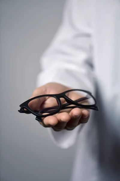 Hombre óptico trayendo un par de anteojos —  Fotos de Stock