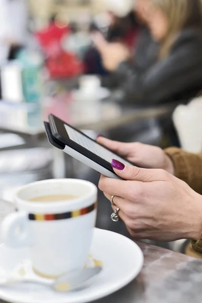 Femeie care utilizează o tabletă pe terasa unei cafenele — Fotografie, imagine de stoc