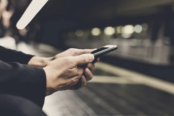 Uomo che utilizza smartphone nella stazione della metropolitana — Foto Stock