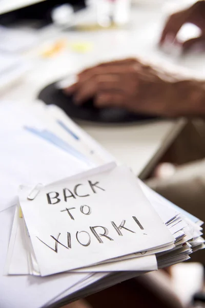 Man på kontoret och text tillbaka att arbeta i en anteckning — Stockfoto