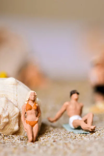 Persone in miniatura in costume da bagno sulla spiaggia — Foto Stock