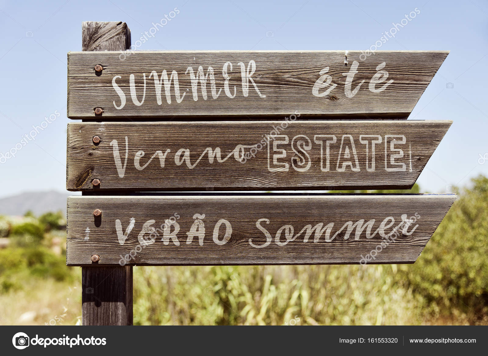 Word summer in different languages in a signpost Stock Photo by