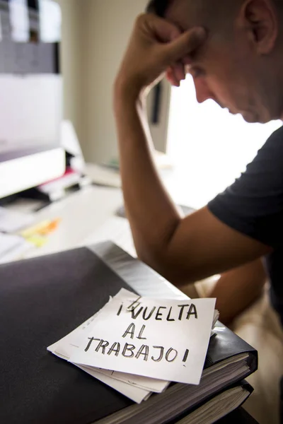 Homem no escritório e texto de volta ao trabalho em espanhol — Fotografia de Stock